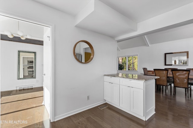 interior space featuring visible vents, dark wood finished floors, and baseboards