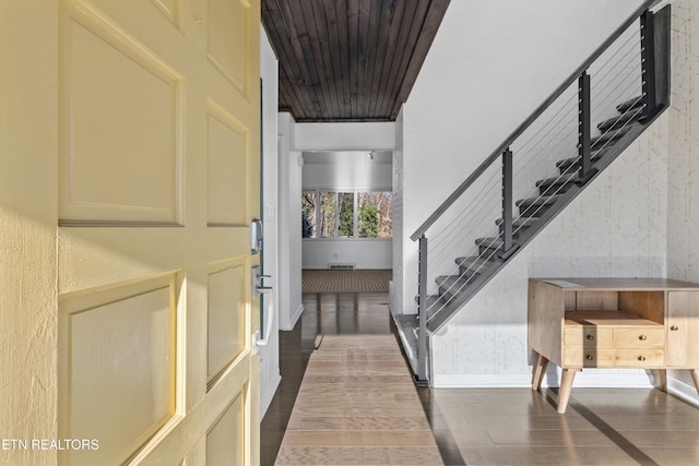 foyer featuring dark wood-type flooring, visible vents, and stairs