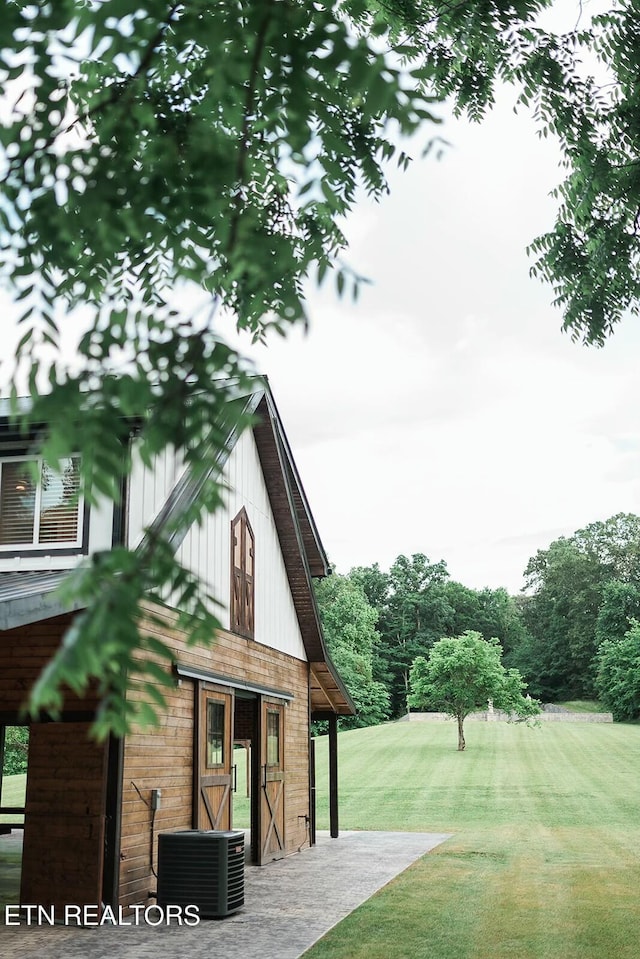 exterior space with central AC unit and a yard