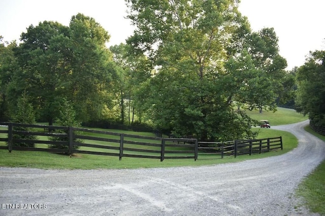 exterior space with a rural view, a lawn, and fence