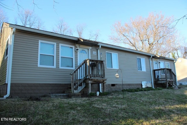 back of property featuring crawl space and a lawn