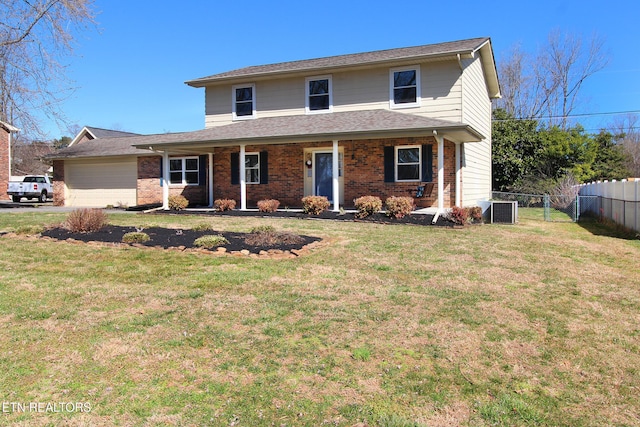 traditional-style house with brick siding, an attached garage, a front yard, fence, and cooling unit