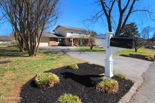 view of front facade featuring a front yard, brick siding, driveway, and an attached garage