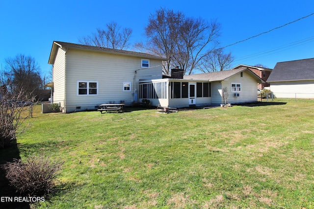 rear view of property featuring a sunroom, a yard, a chimney, and crawl space