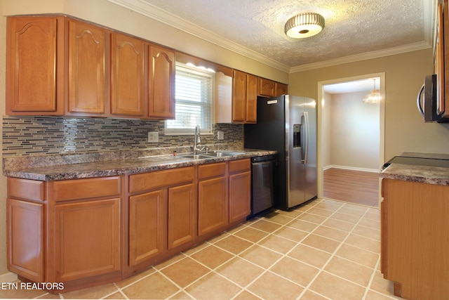 kitchen with appliances with stainless steel finishes, light tile patterned flooring, a sink, and brown cabinets