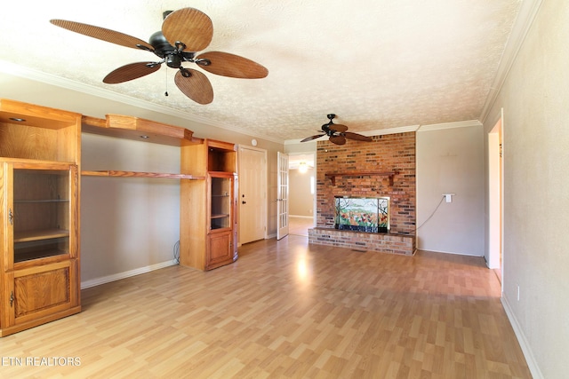 unfurnished living room featuring a textured ceiling, a fireplace, baseboards, ornamental molding, and light wood-type flooring