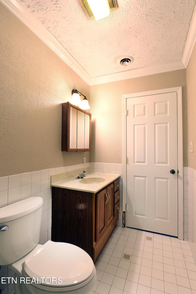 half bath with crown molding, tile walls, visible vents, toilet, and a textured ceiling