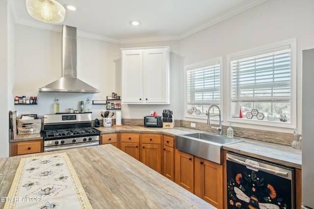 kitchen with stainless steel gas range oven, dishwasher, light countertops, wall chimney range hood, and a sink