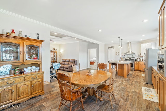 dining area featuring light wood-style flooring, ornamental molding, coffered ceiling, and recessed lighting