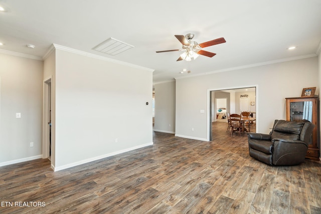 sitting room featuring ceiling fan, ornamental molding, wood finished floors, and baseboards