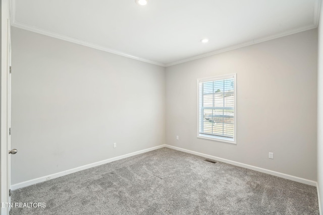 carpeted empty room featuring ornamental molding, visible vents, and baseboards