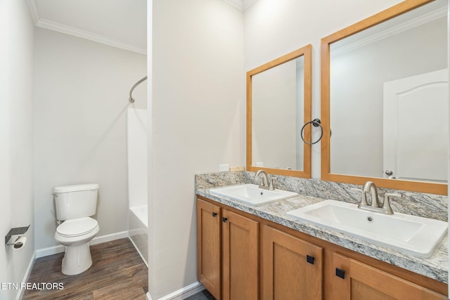 full bath featuring toilet, crown molding, a sink, and wood finished floors