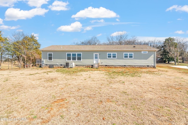 rear view of house with entry steps, central AC unit, crawl space, and a lawn