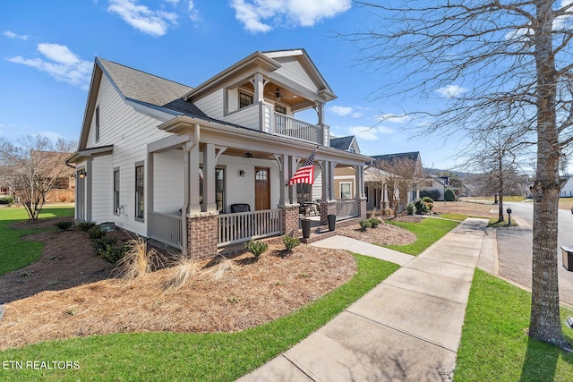 view of front of house featuring a ceiling fan, covered porch, and a balcony