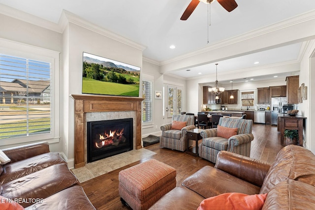 living room with ornamental molding, wood finished floors, a high end fireplace, and baseboards