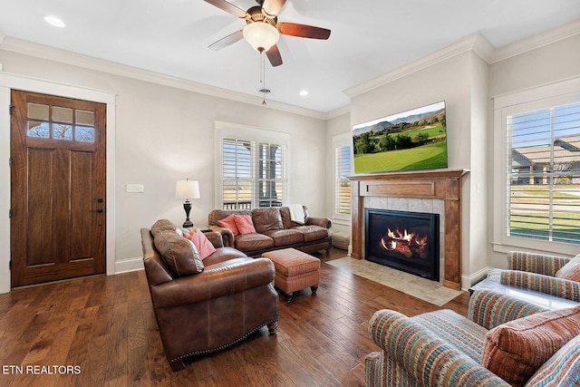 living room featuring crown molding, dark wood finished floors, a premium fireplace, ceiling fan, and baseboards