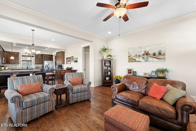 living room with dark wood-style flooring, recessed lighting, ornamental molding, baseboards, and ceiling fan with notable chandelier