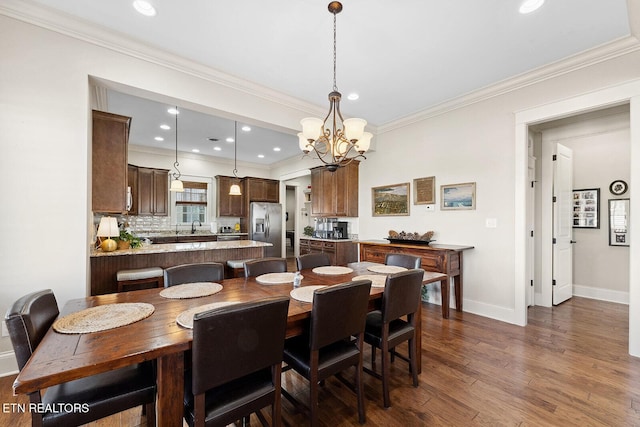 dining room with a chandelier, recessed lighting, dark wood-style flooring, baseboards, and crown molding