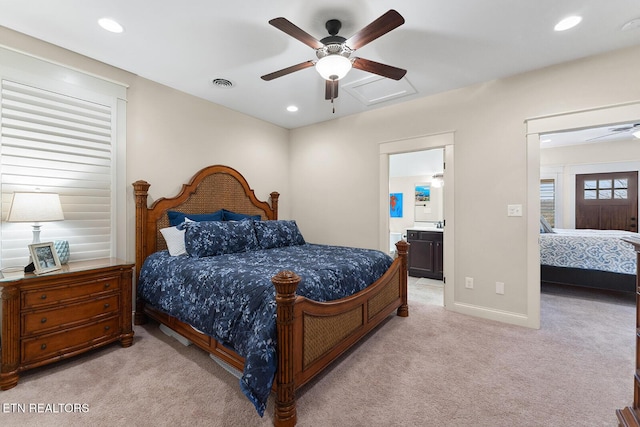 bedroom with light carpet, visible vents, ensuite bathroom, and recessed lighting