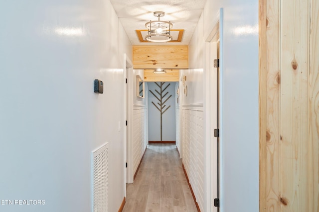 hallway featuring visible vents and light wood-style flooring