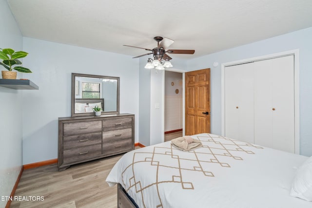 bedroom with a closet, ceiling fan, baseboards, and light wood-style floors