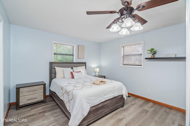 bedroom featuring ceiling fan, baseboards, and wood finished floors