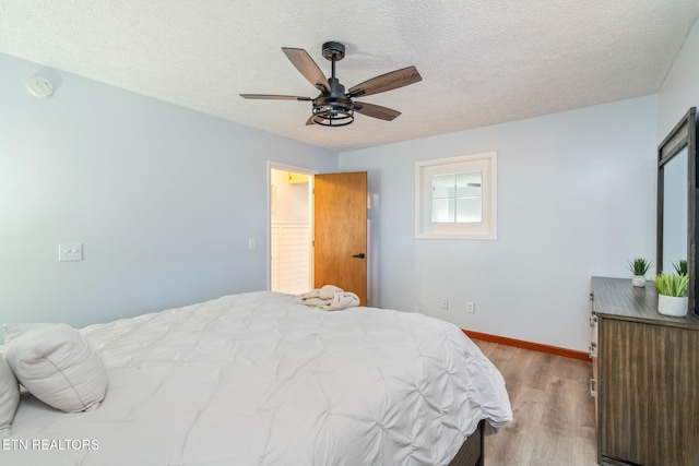 bedroom with baseboards, a textured ceiling, wood finished floors, and a ceiling fan