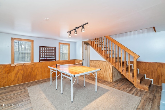 dining space featuring a wainscoted wall, a healthy amount of sunlight, stairs, and wooden walls