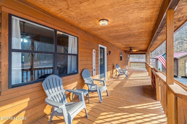 wooden terrace with a ceiling fan and covered porch