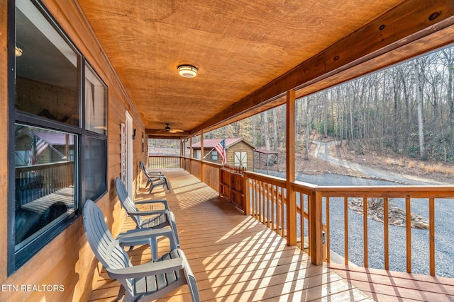 deck with a forest view and a porch