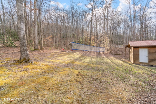 view of yard featuring a forest view and an outdoor structure