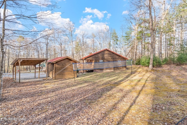 exterior space featuring a detached carport, an outbuilding, and driveway