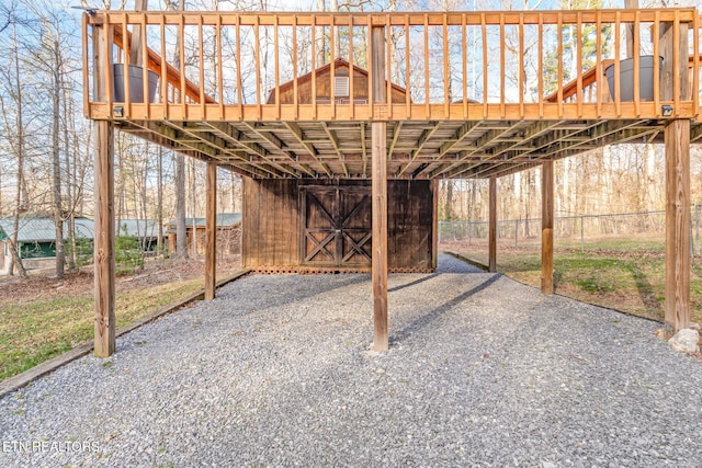 view of patio with gravel driveway and a wooden deck