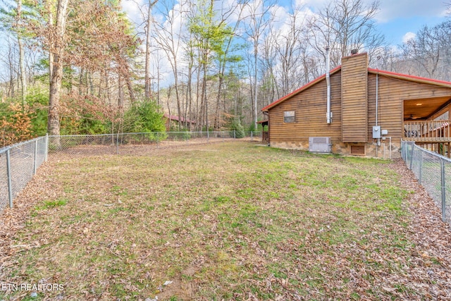 view of yard featuring a fenced backyard, central AC, and ceiling fan