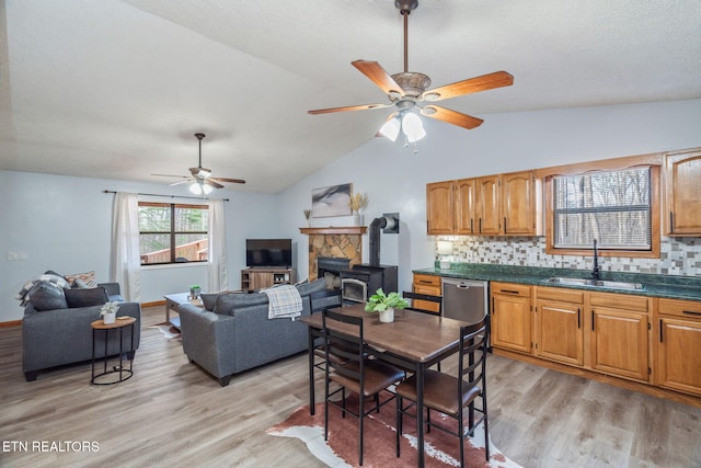 interior space featuring a sink, light wood-type flooring, dark countertops, and dishwasher