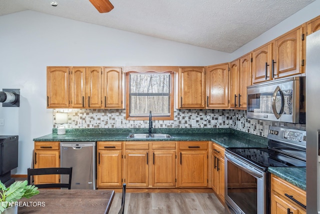 kitchen with dark countertops, stainless steel appliances, and a sink