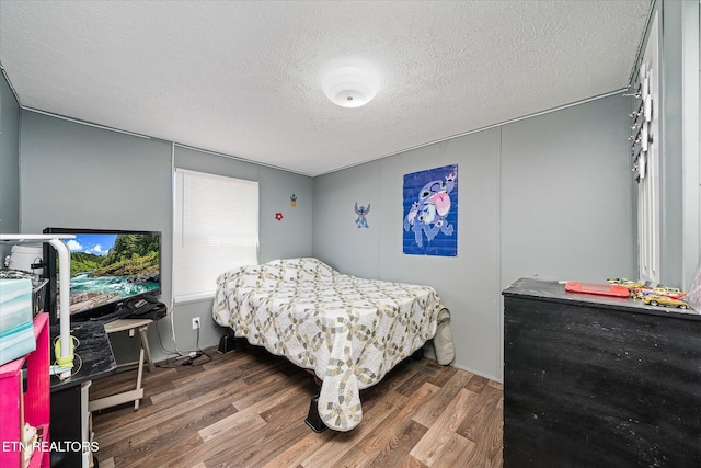 bedroom featuring a textured ceiling and wood finished floors