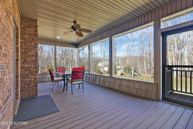 unfurnished sunroom with ceiling fan