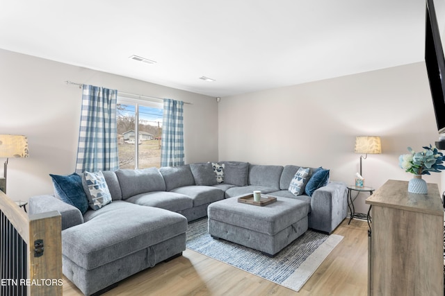 living area with visible vents and light wood-style flooring