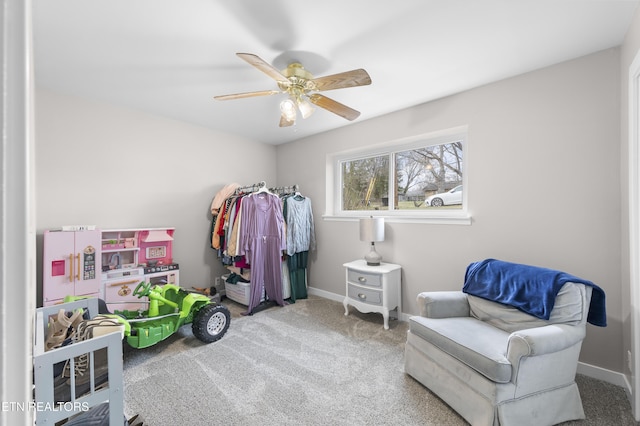 sitting room featuring baseboards, a ceiling fan, and carpet flooring