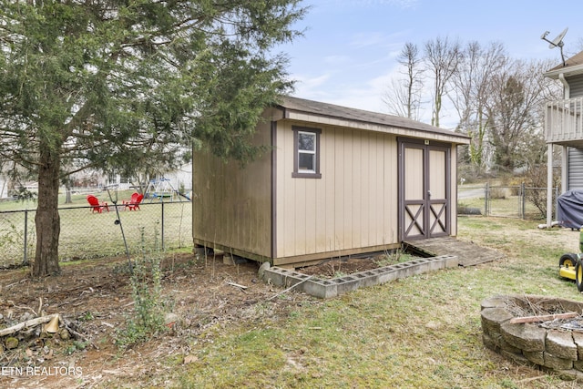 view of shed with a fire pit and a fenced backyard