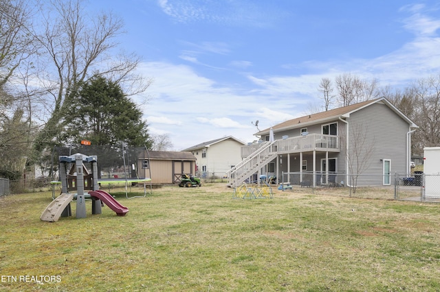 view of yard with a trampoline, a fenced backyard, a shed, a playground, and an outdoor structure