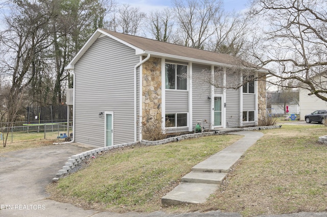 split foyer home with a front lawn and fence