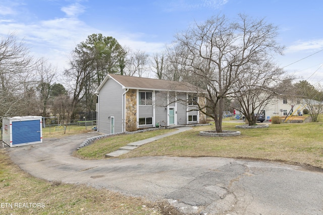 split foyer home with a front lawn, fence, and driveway