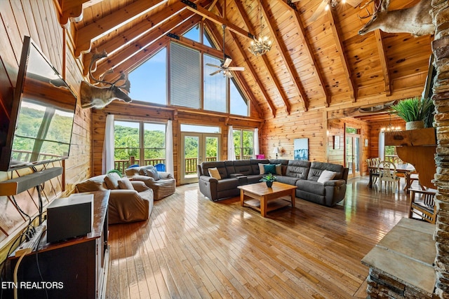 living area with wood ceiling, wood walls, light wood-type flooring, and beam ceiling