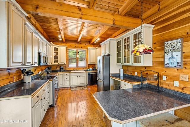 kitchen featuring glass insert cabinets, a breakfast bar, stainless steel appliances, and a peninsula