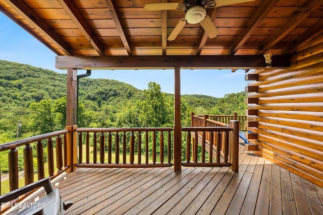 deck with ceiling fan and a wooded view