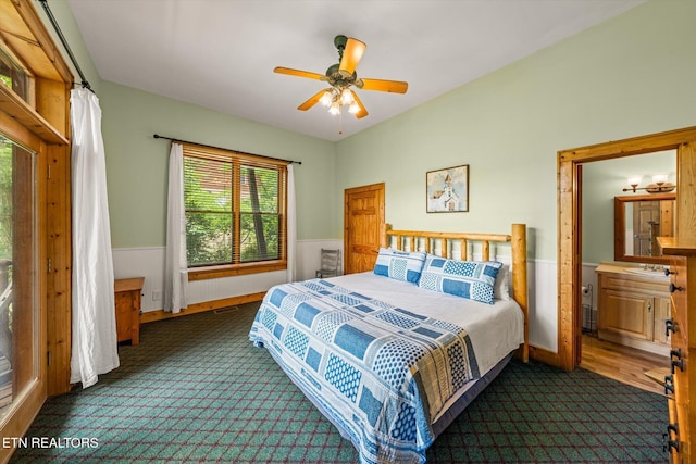 bedroom featuring dark carpet, wainscoting, and visible vents