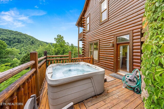 wooden deck featuring a hot tub