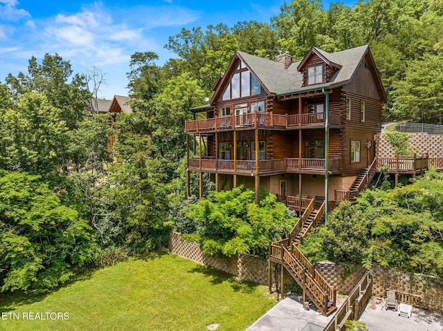 rear view of house with a deck, stairs, a yard, log exterior, and a chimney